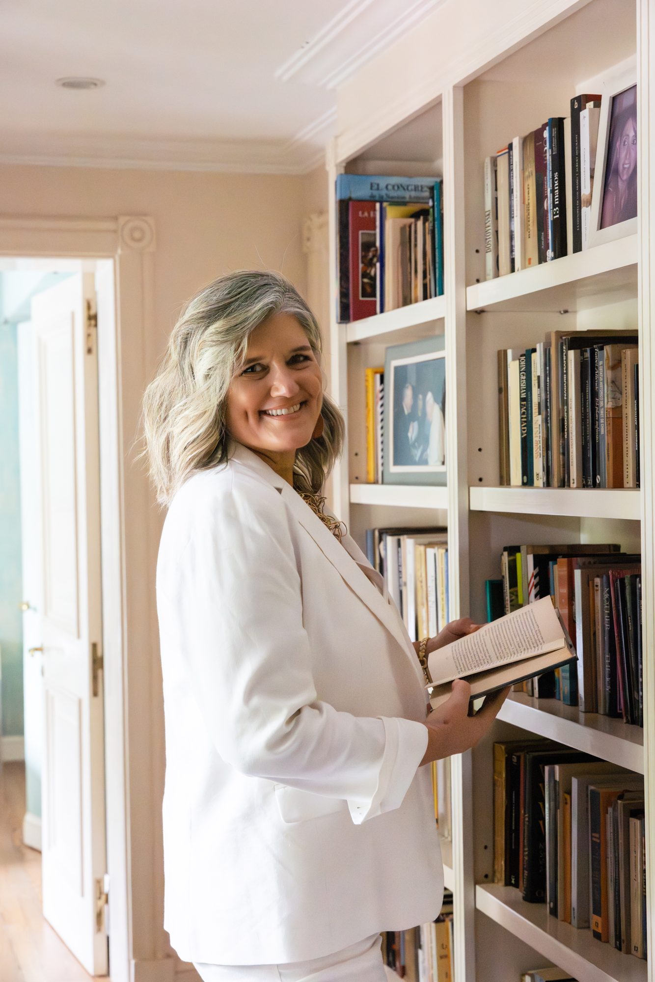 Dolores Hirschmann beside her bookshelf